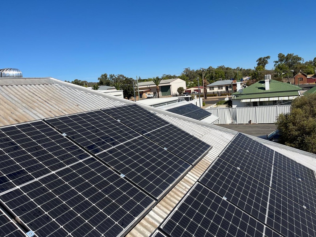 Solar panels installed across a Perth rooftop under clear blue sky